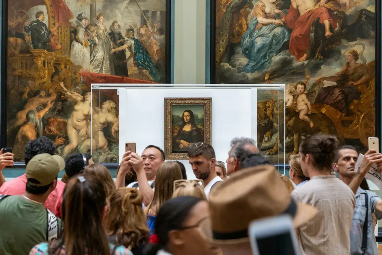 Tłum ludzi ogląda Mona Lisę, dzieło renesansu, w muzeum.