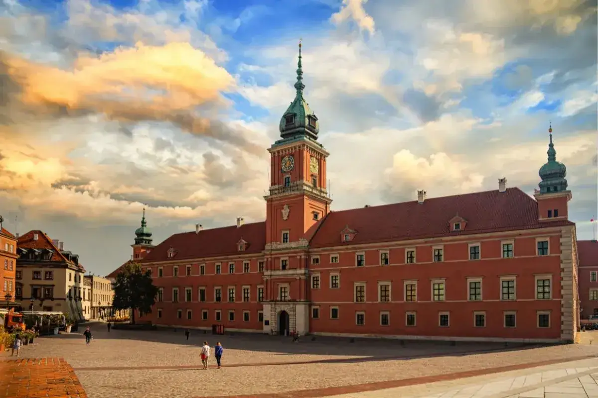 Zamek Królewski w Warszawie, świadectwo świetności renesansu w Polsce, z wieżą zegarową i malowniczym niebem.